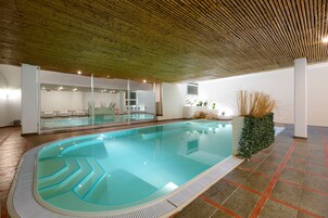 Una piscina al aire libre de temporada, sombrillas