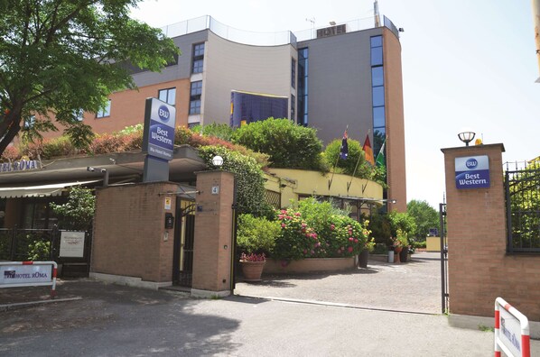 A hotel entrance with a sign for Best Western Blue Hotel Roma, surrounded by greenery and a brick wall. - Best Western Blu Hotel Roma (Rome)