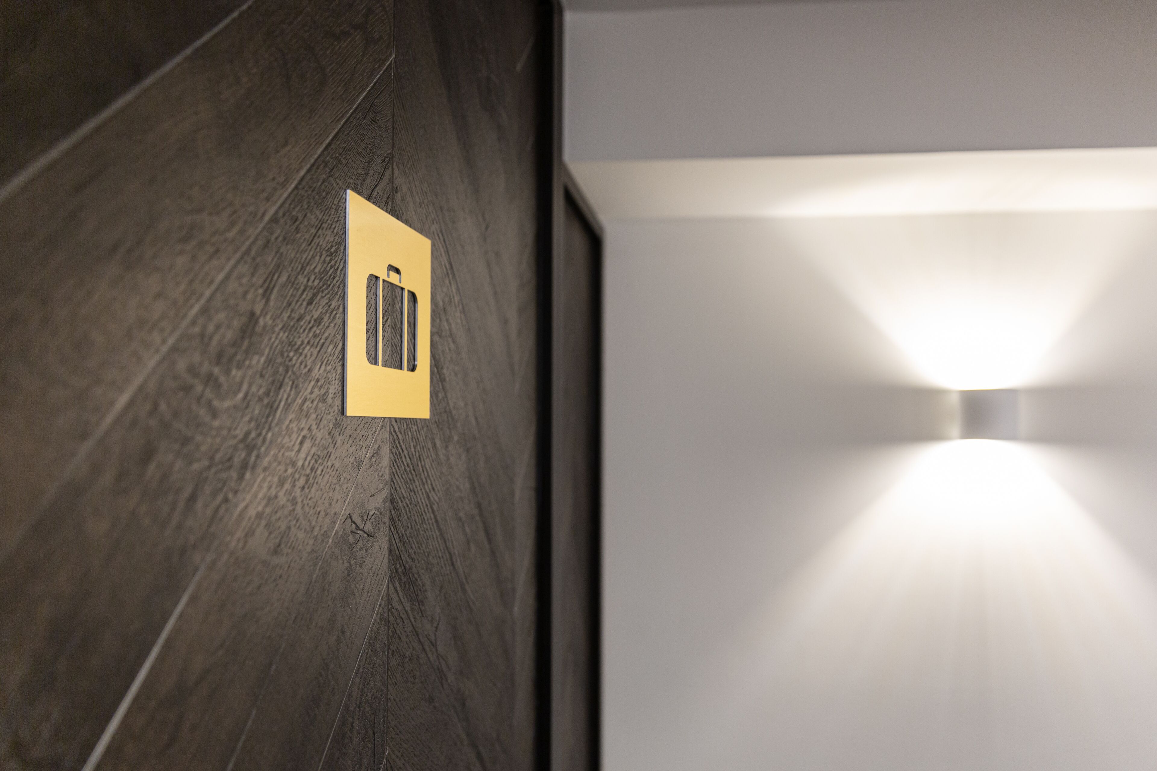 A wall with a textured dark finish and a recessed light fixture.