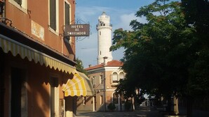Une rue avec un bâtiment portant l’inscription « HÔTEL AL SOFIADOR » et une tour en arrière-plan.