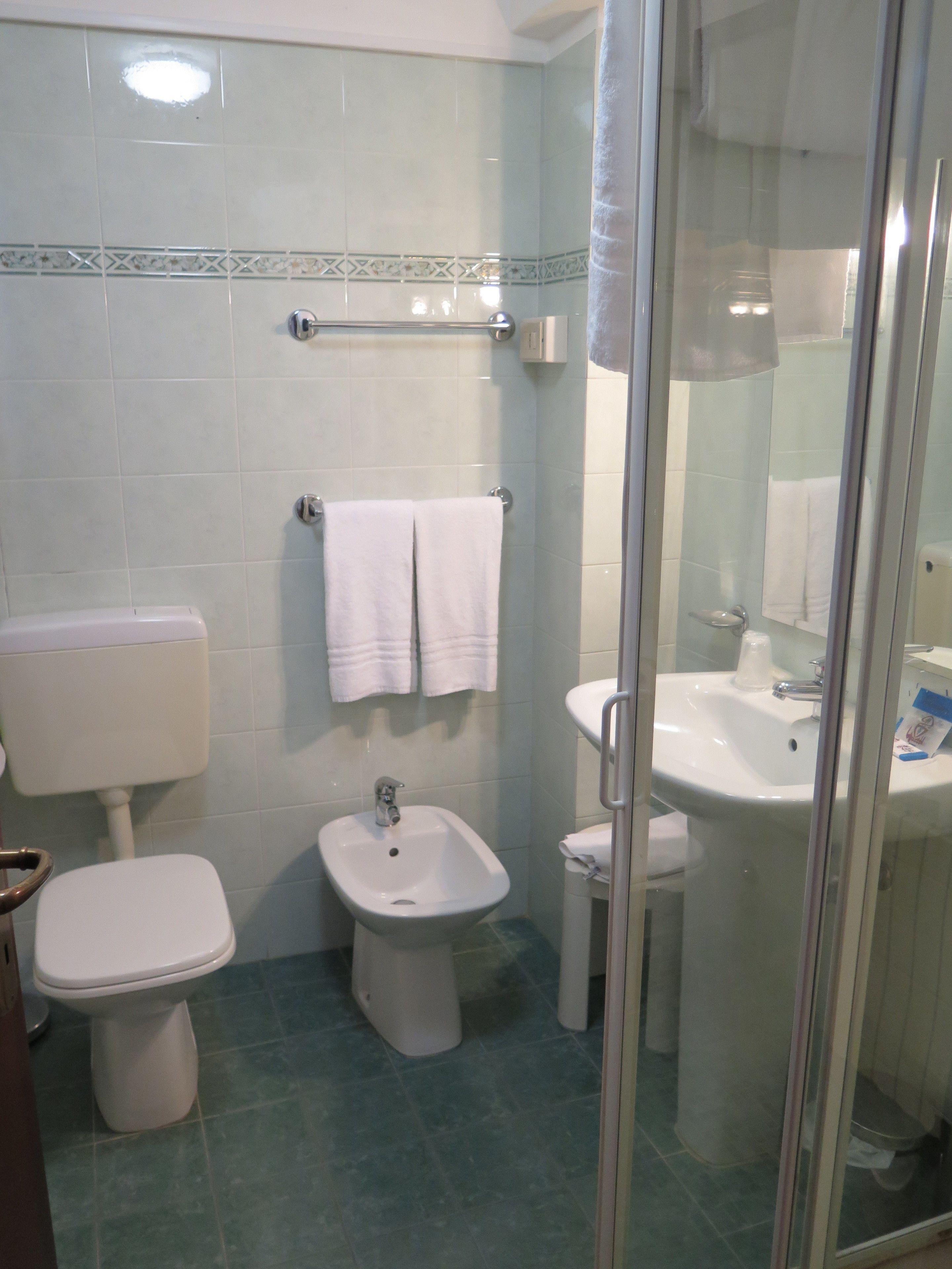 A bathroom with a toilet, bidet, and sink.