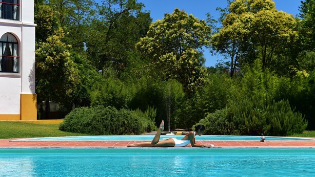 A swimming pool with a person lying on the edge.