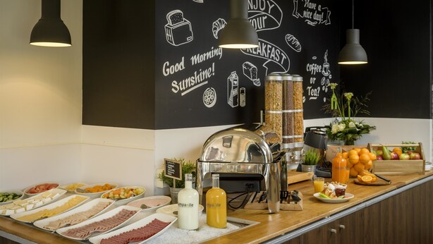 Un buffet de petit-déjeuner proposant une variété de plats et un coin café.