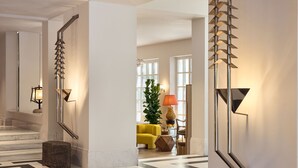 A modern interior with a geometric patterned floor, a staircase, and contemporary lighting fixtures.