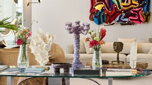 A modern living room with a glass coffee table, decorative vases, and a colorful abstract painting on the wall. - ATHENA Pallas (Athens)