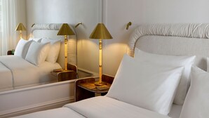 A hotel room with two beds, a bedside table with a lamp, and a mirror. - ATHENA Pallas (Athens)