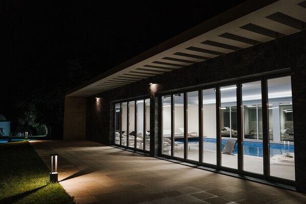 Un edificio moderno con amplios ventanales de vidrio que dan a una piscina.