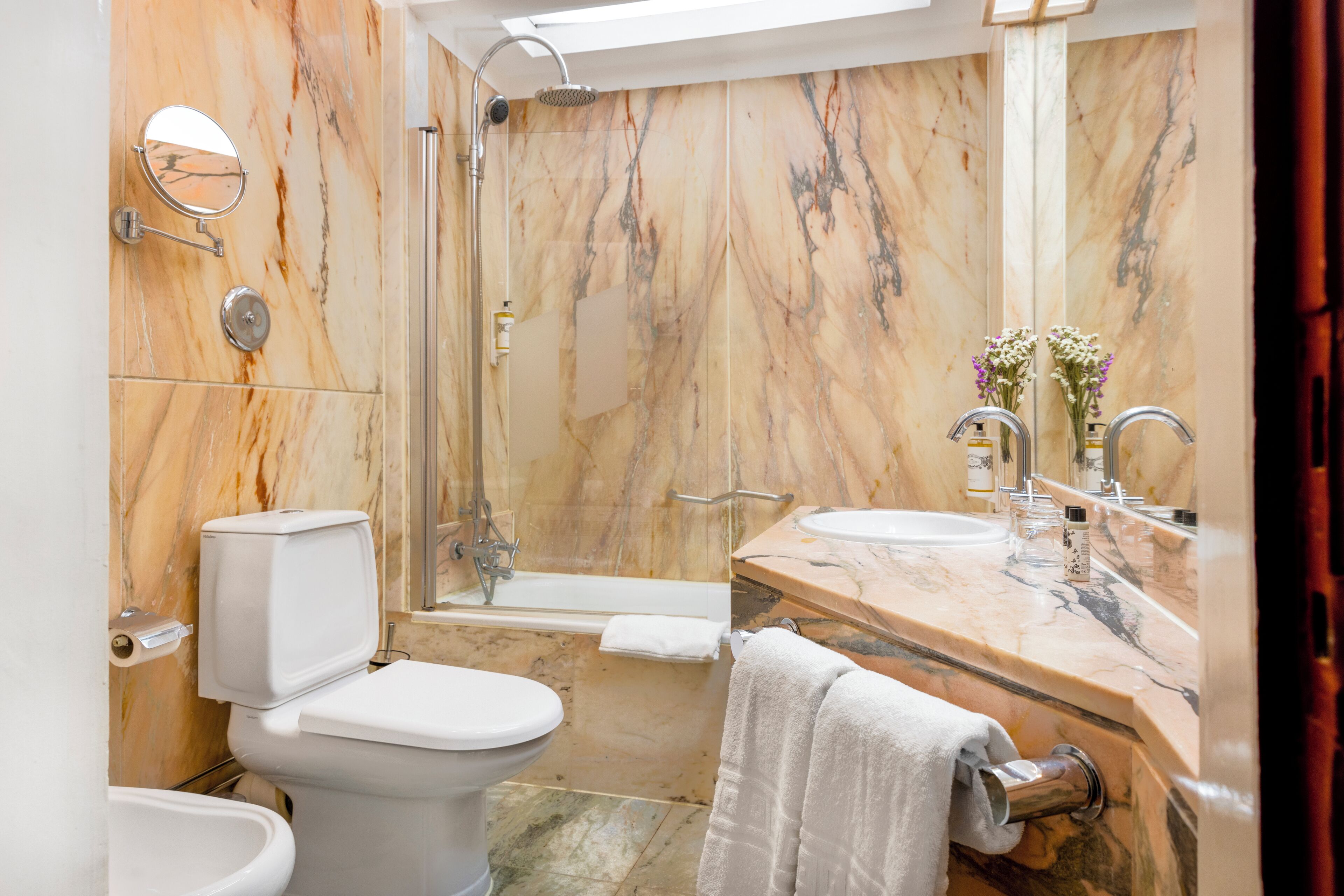 A bathroom with a toilet, bidet, and shower.