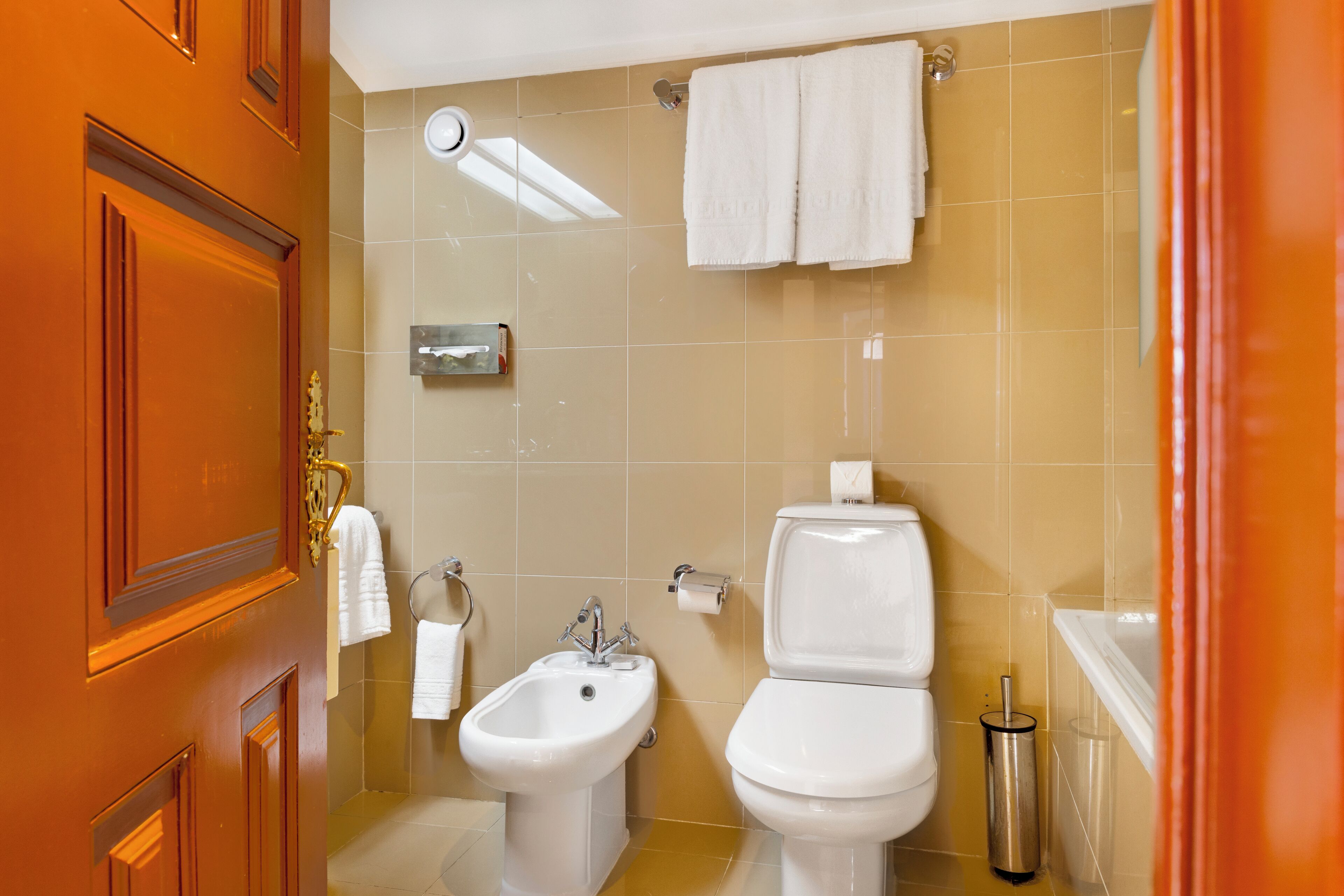 Ein Badezimmer mit einer Bidet-Funktion, Toilette und Waschbecken.