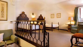 A hotel room with a bed, a sofa, a table, and a chair.