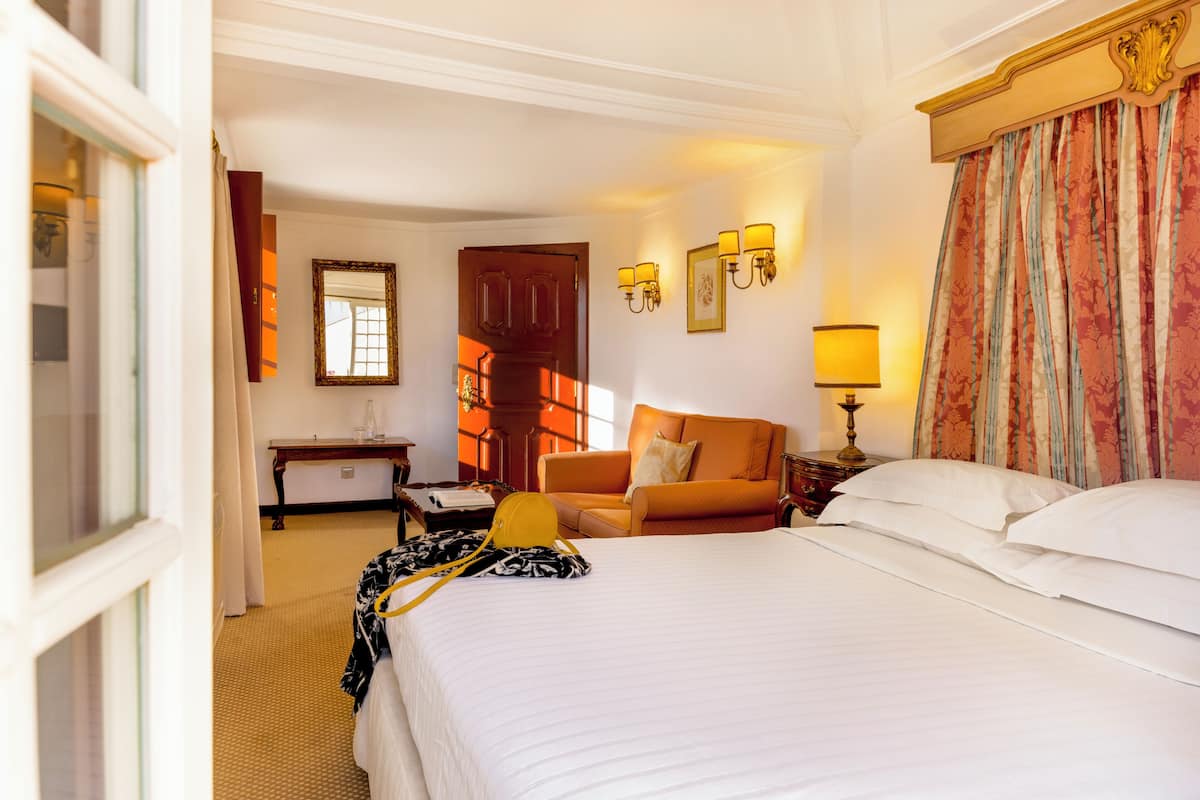 Ein Hotelzimmer mit einem großen Bett, einer Couch, einem Schreibtisch und einem Stuhl.