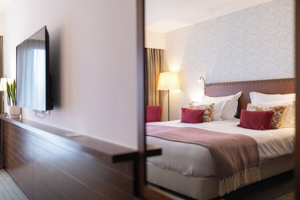 A hotel room with a large bed, a flat-screen TV mounted on the wall, and a bedside table with a lamp. - Pousada Caniçada - Gerês (Vieira do Minho)