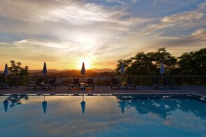 Una piscina al aire libre, sillones reclinables de piscina