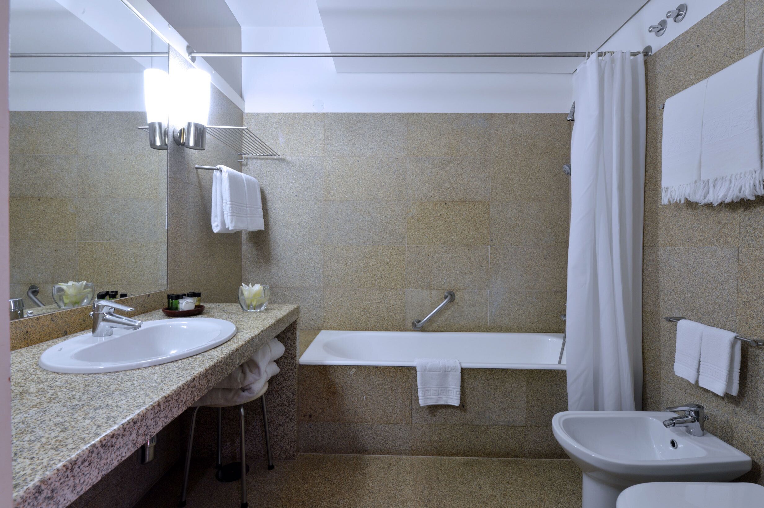Une salle de bain avec deux lavabos, une baignoire et un rideau de douche.