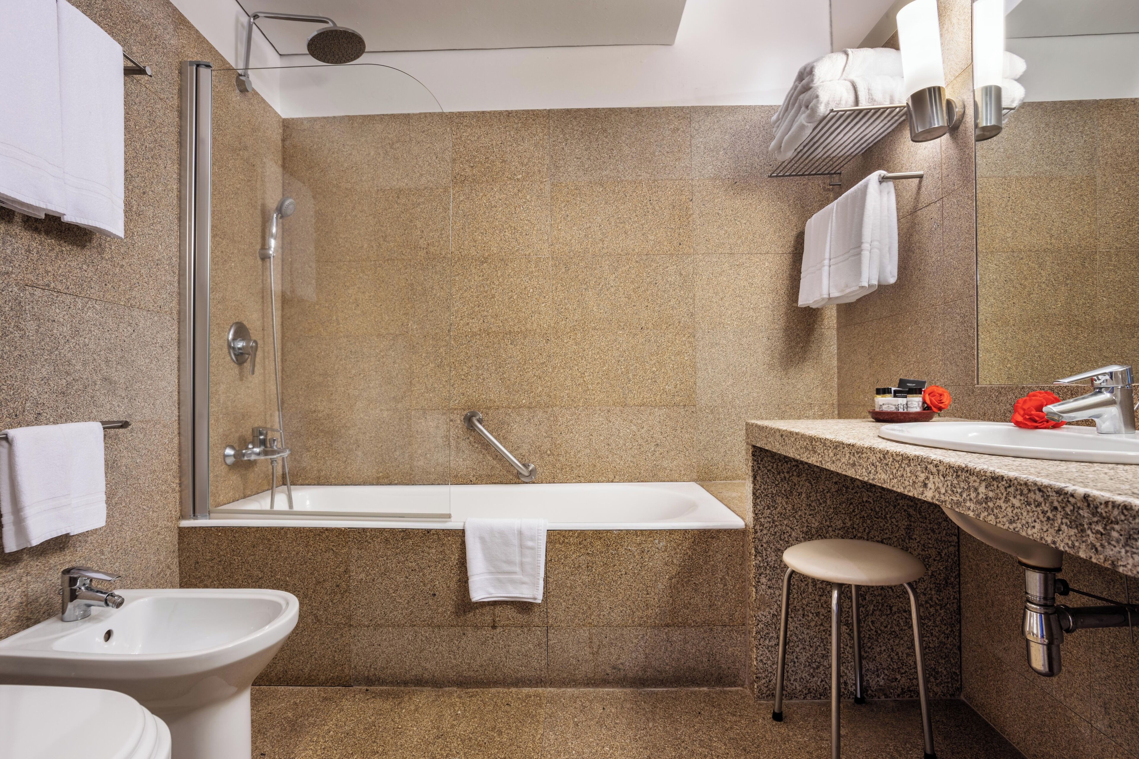 Een moderne badkamer met een bad, een wastafel en een toilet met douchefunctie.