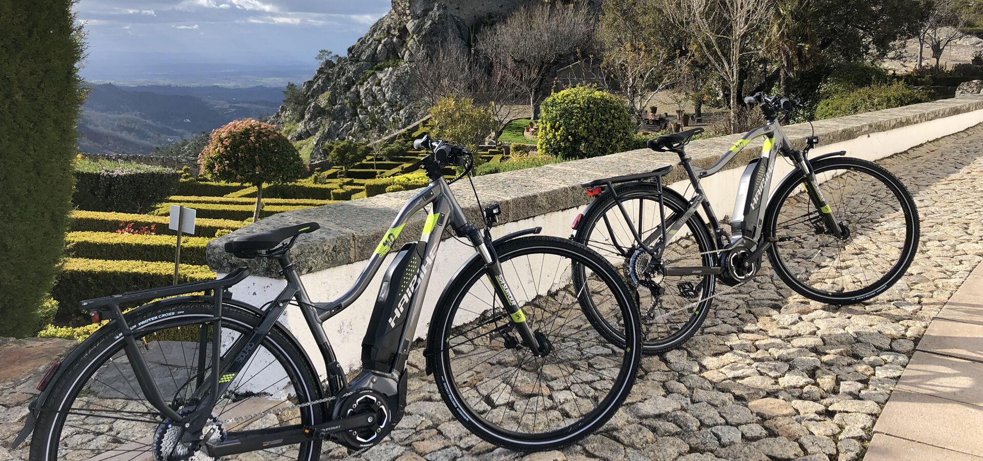 Biciclette parcheggiate su un sentiero in pietra con una vista panoramica su un paesaggio montuoso.