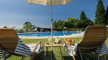 Alberca al aire libre y camastros