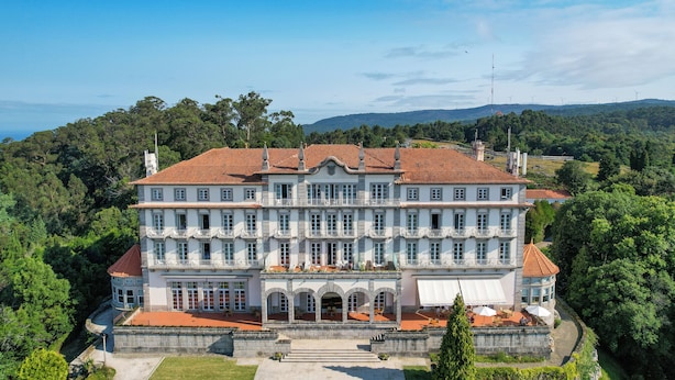 Un grand immeuble à étages, doté d’une façade symétrique, de nombreux balcons et d’une entrée centrale surmontée d’un portique.