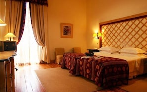 A hotel room with a double bed, two bedside tables, a desk with a lamp, a chair, and a window with curtains. - Lam Hotel Convento do Desagravo (Oliveira do Hospital)