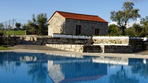 A stone building with a red-tiled roof, adjacent to a swimming pool. - Lam Hotel Convento do Desagravo (Oliveira do Hospital)