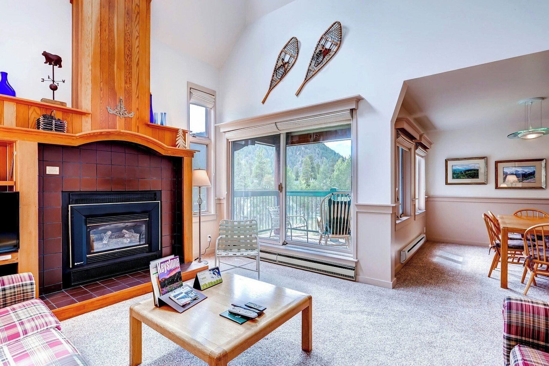 Una sala de estar con chimenea, un balcón con vistas y un comedor.