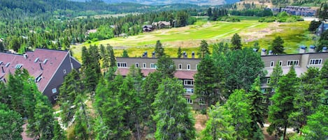 A residential area with houses, a golf course, and a mountainous backdrop.