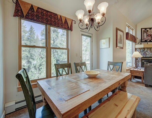 A dining area with a wooden table, chairs, and a chandelier. - Forest Condominiums by Vail Resorts (Keystone)