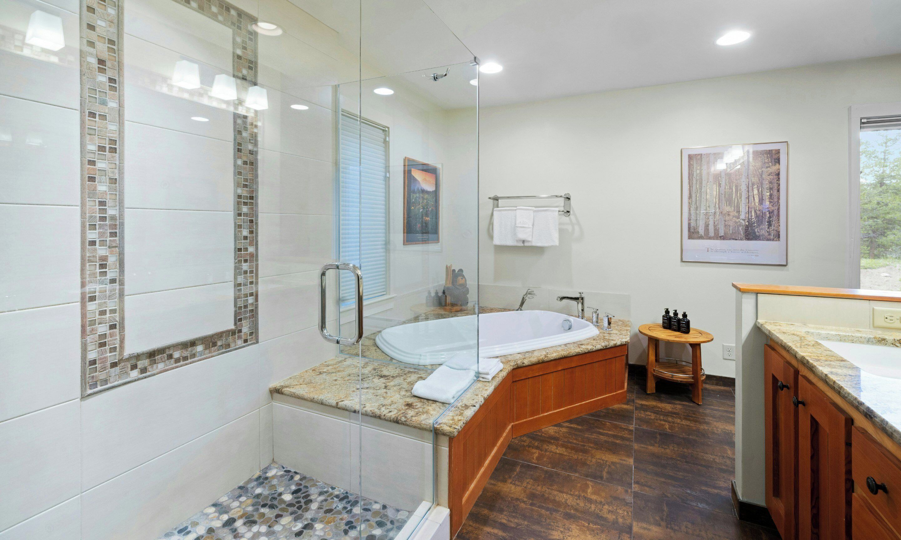 A modern bathroom with a glass-enclosed shower, a freestanding bathtub, and a vanity with a sink.