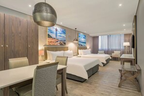 A hotel room with a bed, a desk, a chair, a lamp, and a painting of a lighthouse. - Protea Hotel by Marriott Durban Umhlanga (Umhlanga)