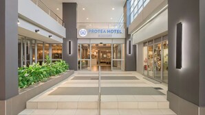 A hotel entrance with a sign reading 'PROTEA HOTEL MARRIOTT,' a staircase, and a glass door leading inside. - Protea Hotel by Marriott Durban Umhlanga (Umhlanga)