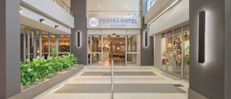 Ein Hotel Eingang mit einem Schild, das 'PROTEA HOTEL MARRIOTT' zeigt, einer Treppe und einer Glastür zum Innenbereich.