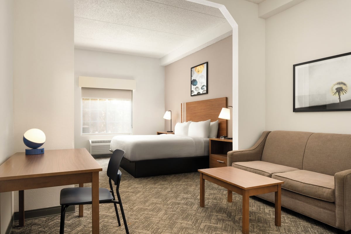 Escritorio, cortinas blackout y tabla de planchar con plancha