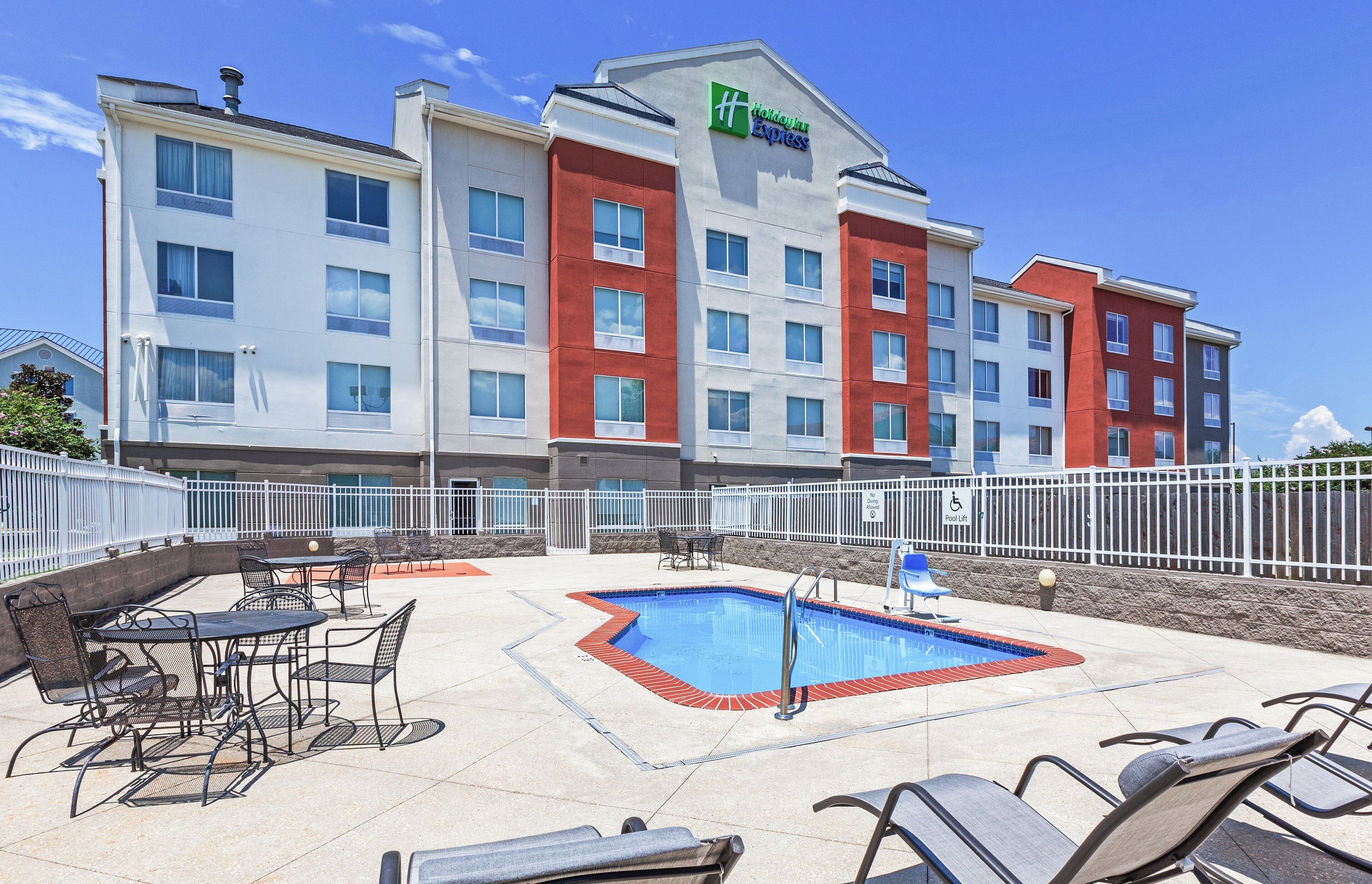 Um hotel Holiday Inn Express com piscina e área de estar ao ar livre.
