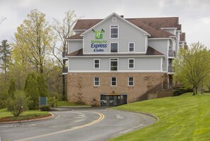 Un bâtiment de l’hôtel Holiday Inn Express & Suites, avec une façade en briques, de nombreuses fenêtres et un parking.