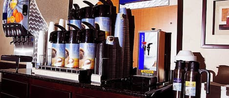 Ein Kaffeeangebot mit mehreren Kaffeeautomaten, einem Wasserspender und einem Schild mit der Aufschrift 'Smart Roast'.