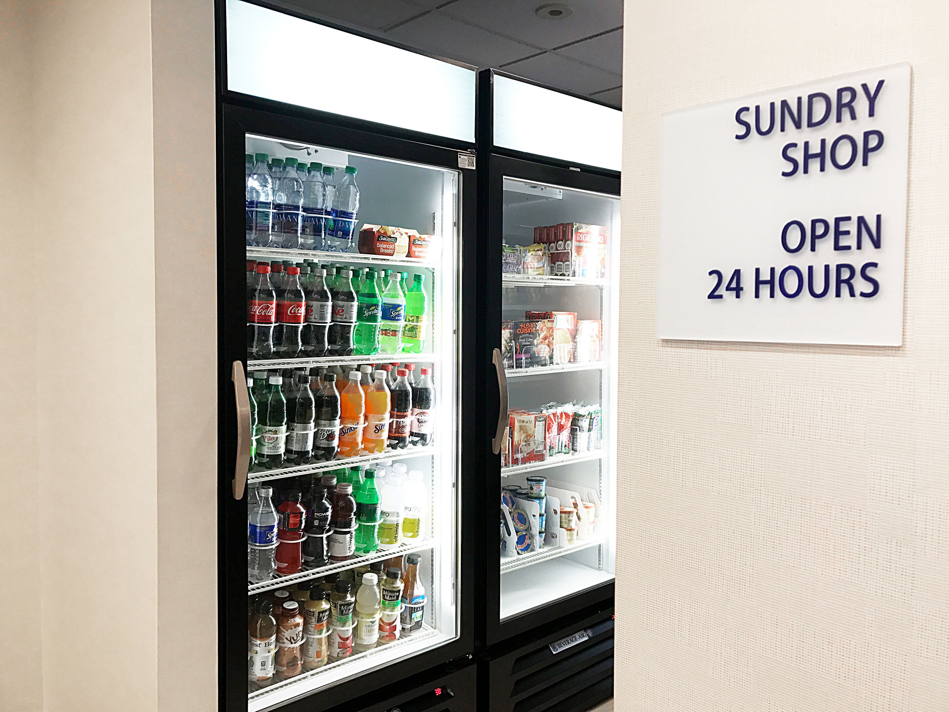 A vending machine with a sign indicating it's a sundry shop open 24 hours.