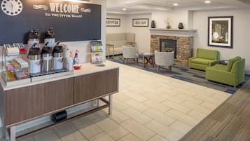 A reception area with a counter, hot water dispensers, and a welcome sign.