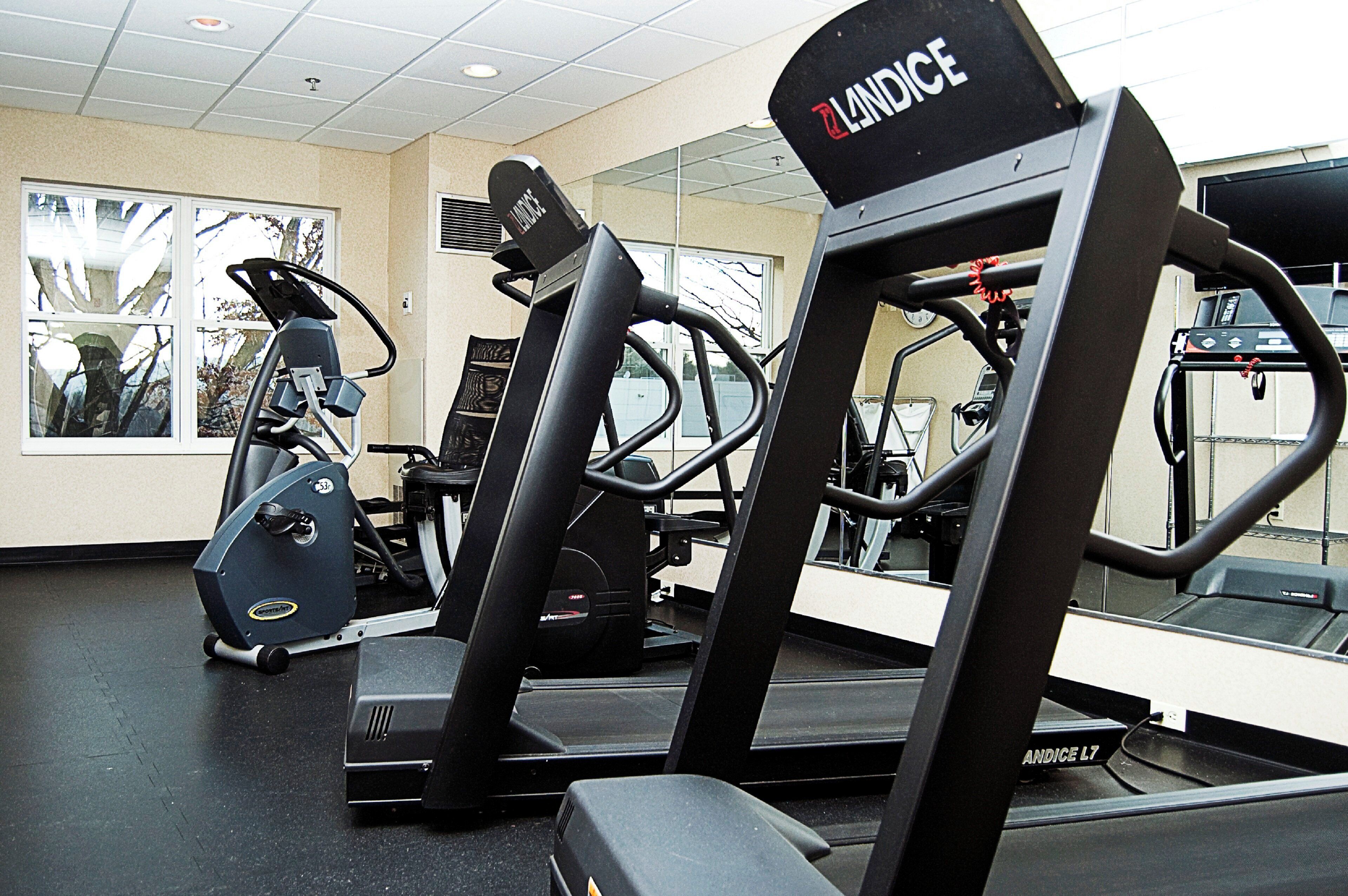 A gym with various exercise equipment including treadmills and weight machines.