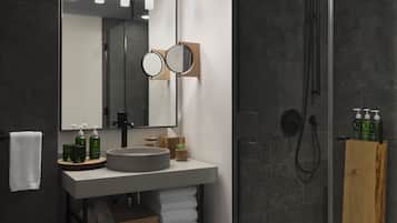 A modern bathroom with a glass-enclosed shower, a large mirror, and a vanity with a sink and towel storage.