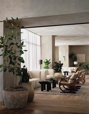 A modern living room with a sofa, armchairs, a coffee table, and potted plants. - 1 Hotel San Francisco (San Francisco)