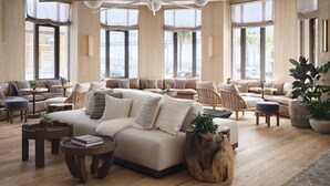 Un salón amplio con un sofá grande, varias opciones de asientos y un ventilador de techo.
