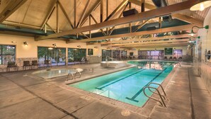 Ein Hallenbad mit deutlich markierten Bahnen, einer Whirlwanne und Sitzbereichen.