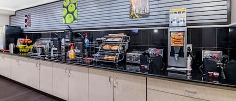 Un mostrador de desayuno autoservicio con diversas opciones de comida y condimentos.