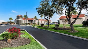 La Quinta offers a beautifully manicured lawn with vibrant flowers and a paved entrance.