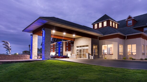 A hotel with a covered entrance, stone facade, and multiple windows. - Holiday Inn Express Mystic by IHG (Mystic)