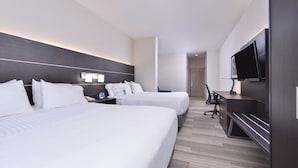 A hotel room with two beds, a desk, a chair, a TV, and a door. - Holiday Inn Express Mystic by IHG (Mystic)