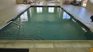 A large indoor swimming pool with clear water, surrounded by tiled walls and windows. - Holiday Inn Express Mystic by IHG (Mystic)