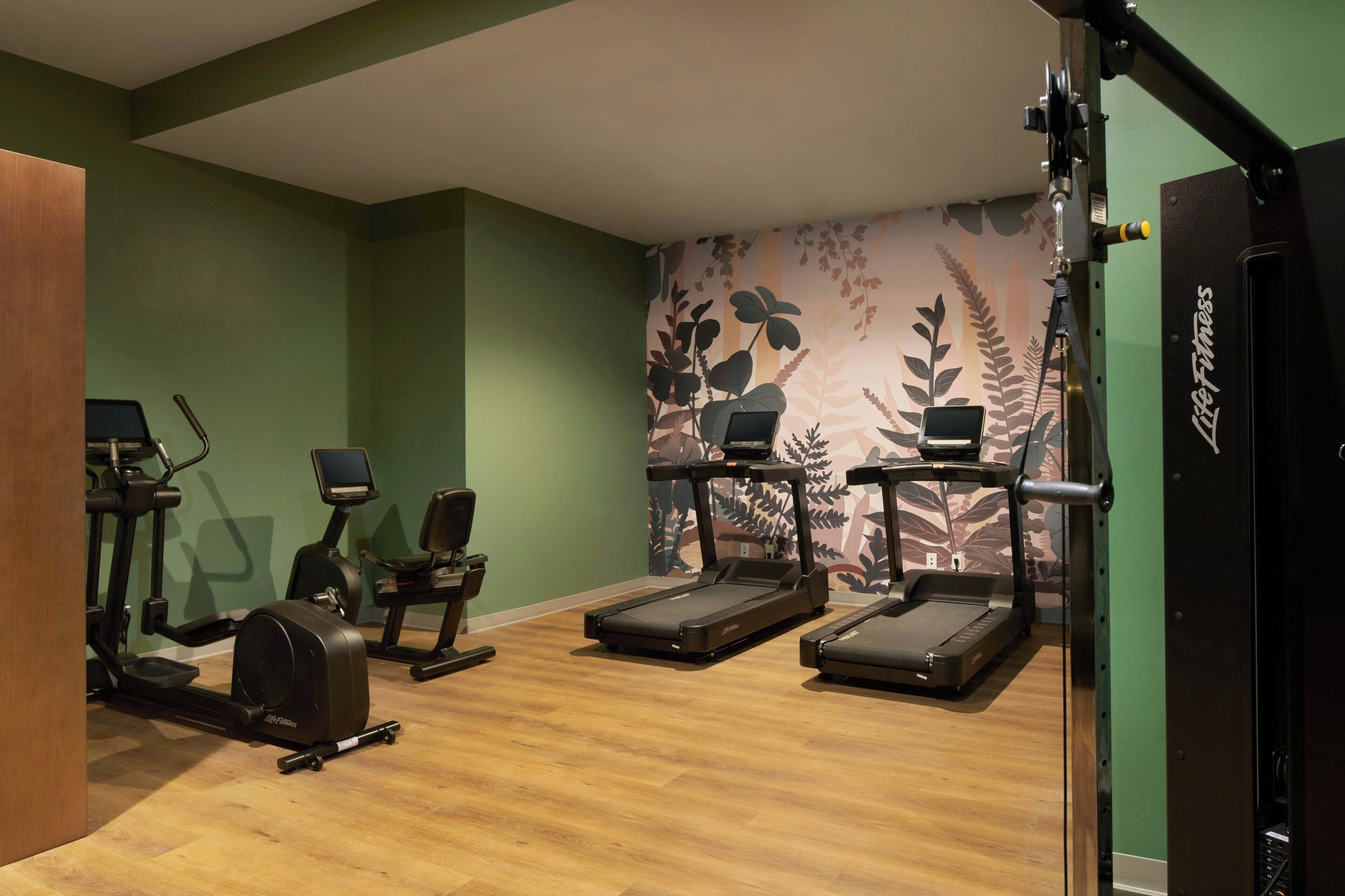 A gym with treadmills, elliptical machines, and a stationary bike.