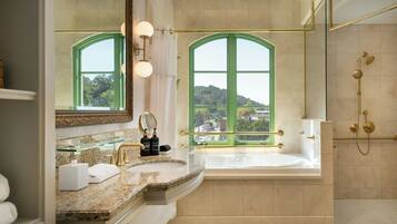 A modern bathroom with a large window, a bathtub, and a shower area.