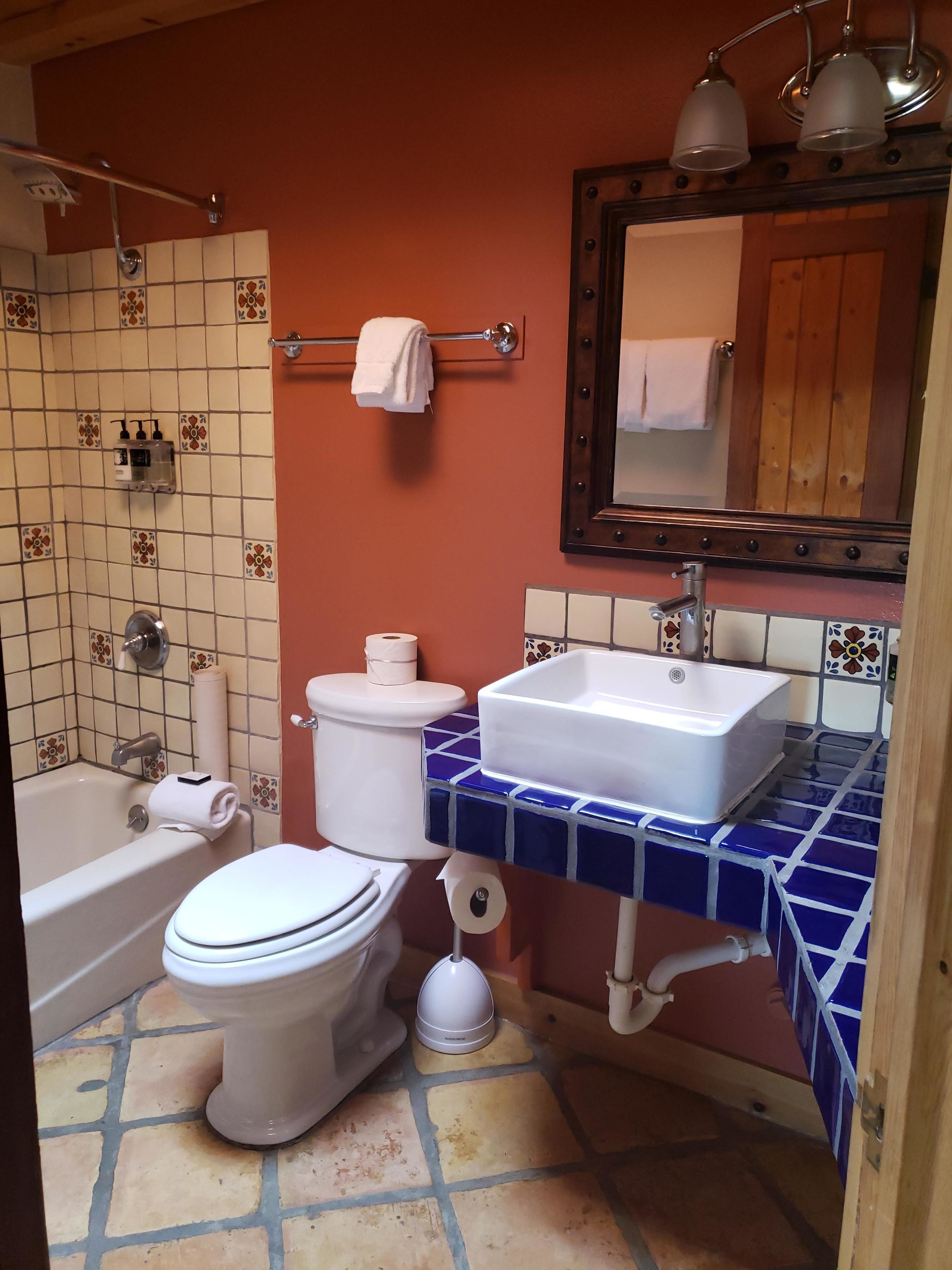 A bathroom with a bathtub, toilet, sink, and shower.
